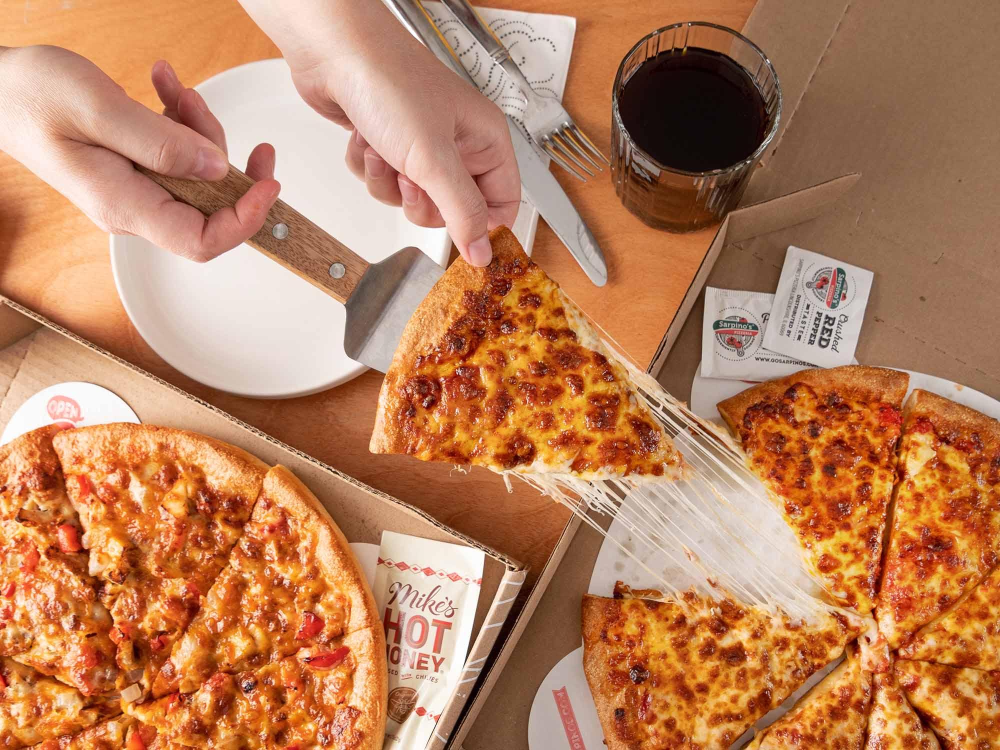 Pizza slice being picked up from the table